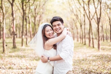 happy asian couple in love with tree arch at park