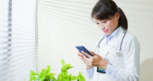 asian doctor woman use smart phone in the clinic