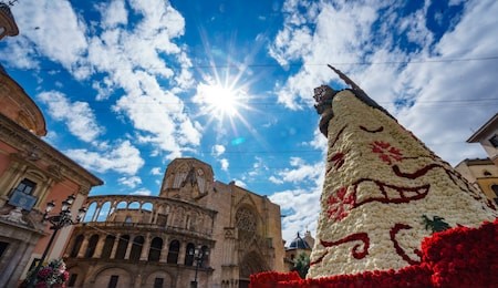 wide angle bottom view of las fallas virgin cape built with flowers against the sun with ray lights, valencia