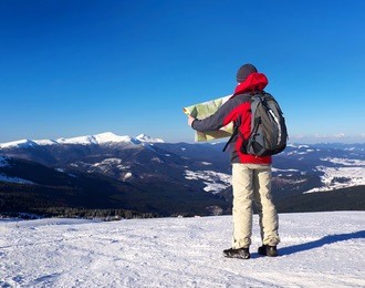 tourist with map in the mountain valley. sport and active