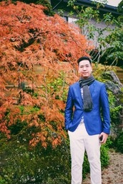 portrait of asian male tourist traveler  wearing a suit with beautiful fall foliage autumn season in tokyo japan. 