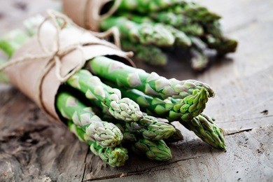 bunch of fresh asparagus on wooden table