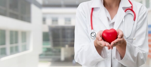 doctor holding a red heart at hospital office. medical health care and doctor staff service concept.