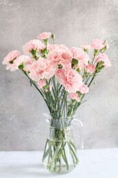 gentle pink carnation flowers in vase on grey background 