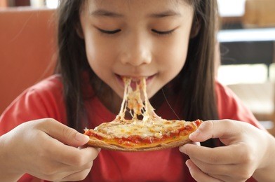 thai girl enjoy eating pizza.