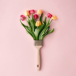 creative spring concept made with paint brush and colorful tulip flowers on pastel pink background. minimal nature flat lay.
