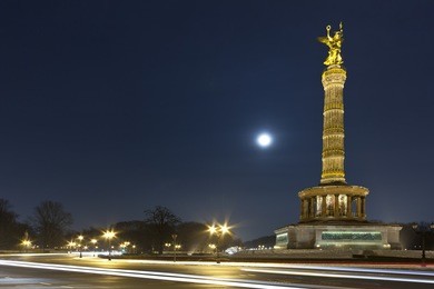 the victory column is a famous sight in berlin. impressive siegessaule monument with its golden angel overlooking the huge tiergarten park in berlin at night.