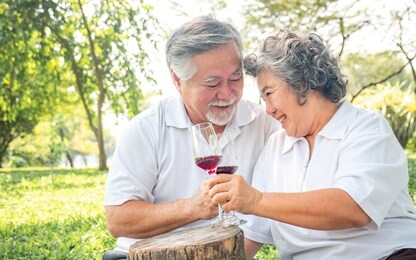 happy senior couple health care in park , relax asian older man and woman celebrate anniversary drink wine and smile ,people lifestyle concept.