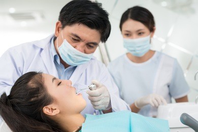 professional team of a dentist and his assistant performing a dental procedure