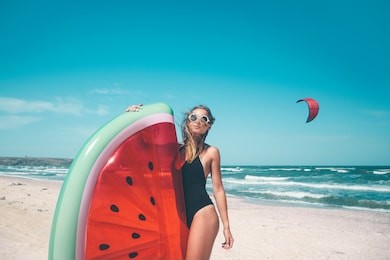 model with watermelon lilo at the beach. summer vacations, idyllic scene.