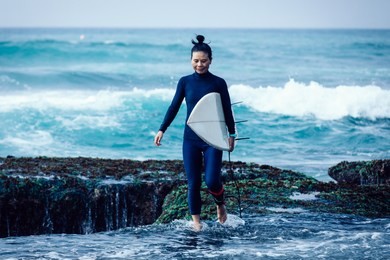 woman surfer with surfboard going to surf