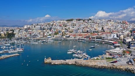 aerial drone bird's eye view panoramic photo of iconic round shaped picturesque port of mikrolimano with sail boats and yachts docked and beautiful clouds, piraeus port, attica, greece