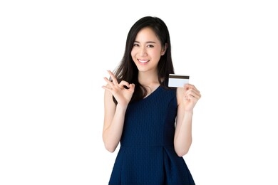 young smiling beautiful asian woman showing credit card with okey gesture isolated on white background
