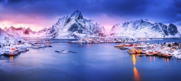amazing panoramic view on lovely arctic village reine on lofoten islands in norway, scandinavia, europea. beautiful polar peaks and dramatic sunset sky in background.