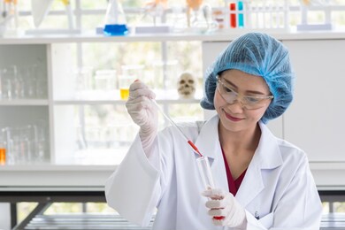 female scientist was smiling with result of profressional chemical test when drop red chemical liquid into test tube glass in laboratory look she could find solution for research healthcare & medicine