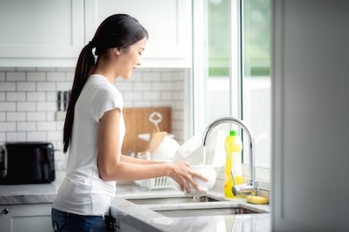 asian lady wash a dish in kitchen room