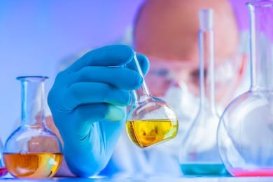 chemical examination of food. chemist conducts a test. researcher studies the results of the experiment. chemical laboratory. chemist in a protective mask and glasses. respiratory protection.