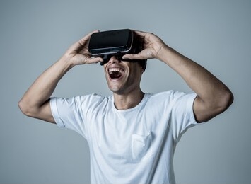 amazed african american man using vr headset glasses, feeling excited about simulation, exploring virtual reality making gestures interacting with new virtual world. in new technology concept.