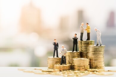 miniature people: small businessmen standing on stack of coins, money, financial, business growth concept.
