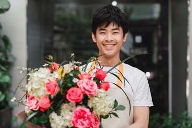 flower shop assistant offering a bunch of flowers
