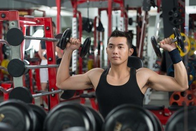 image of a strong man lifting free-weights to build biceps