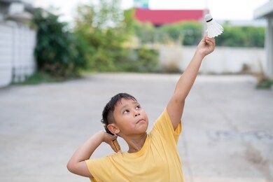 asian boy playing badminton at home