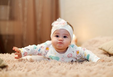 cute little girl with ballons sittimg on bed. happy birthday, five mouth old baby - image