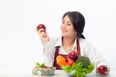 asian young woman is happy holding fresh fruit apple with vegetables,  healthy, fresh food, clean eating recipes to fuel body from the inside out concept.
