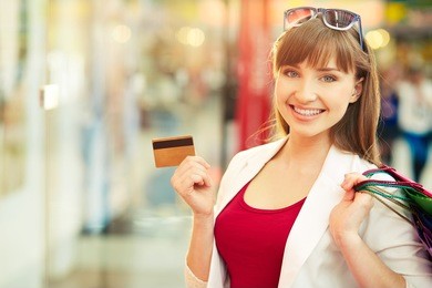 pretty lady showing credit card in the mall