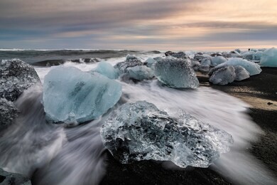 ice rock with black sand beach at jokulsarlon beach at sunset. diamond beach in southeast iceland.