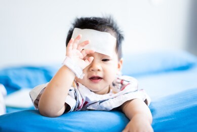unhappy asian little baby child sick with cool fever jel pad on forehead
