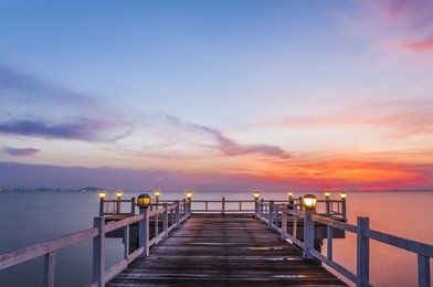 wooden bridge into the sea at sunset