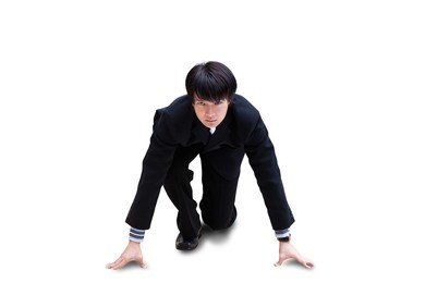attractive young nepalese businessman with suitcase kneeling, ready for race, isolated over white background with clipping path