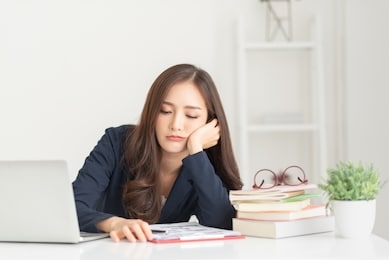 sad young woman employee having problems about her debts and financials. frustrated asian beautiful businesswoman feeling depression, exhausted, tired, lazy during working at the office.