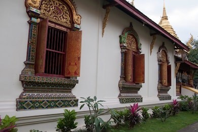 chiang mai thailand, view of decorated windows and shutters along the side of  wat chiang man