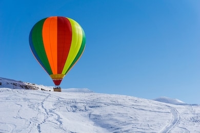 colorful hot air balloon in winter scenery. attraction in gudauri ski resort, georgia.