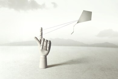 wooden hand driving kite up to the sky, surreal concept