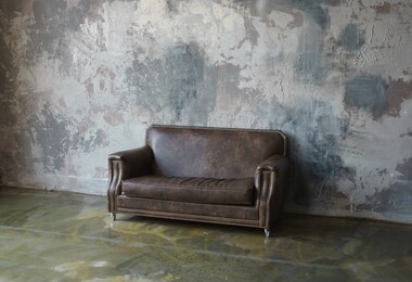 luxury room interior. stylish loft livingroom. brown leather sofa near textured cement wall