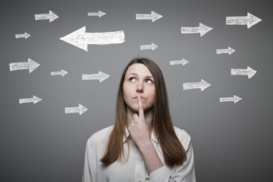 uncertain girl is looking at arrows. girl full of doubts and hesitation.