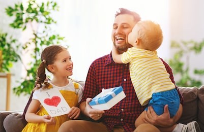 happy father's day! children congratulates dad and gives  him a gift and postcard 
