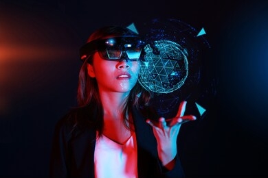 business woman try vr glasses hololens 1 in the dark room. young asian girl experience ar with glow energy ball on hand. mixed reality future technology concept