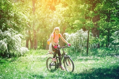 girl riding a bike in the woods.
