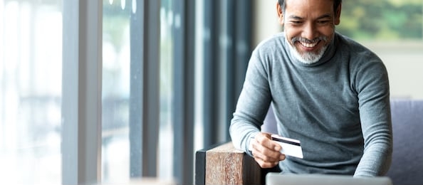 attractive bearded hipster asian father or hispanic old man using laptop and credit card payment shopping online with customer network connection via omni channel system. older man with technology.