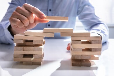 conceptual photo of businessman building bridge to connect two towers