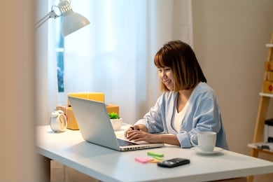 candid of happy young attractive asian woman work at home in evening or late night with sme business owner, young entrepreneur or freelance concept. young asian student study online in self education.