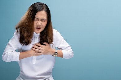 woman has chest pain isolated over blue background
