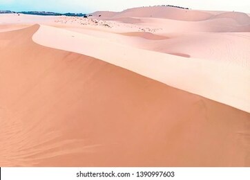 sandy landscape. sand with a reddish pink tint. long sand dune.