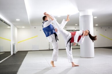 exchange of high kicks during training of taekwondo between two fighters