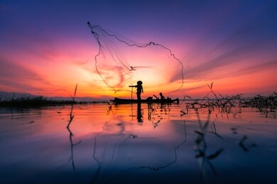 silhouette of myanmar fisherman on wooden boat ,myanmar fisherman in action catching freshwater fish in nature river, myanmar traditional fishermen at the sunset near inle lake,myanmar