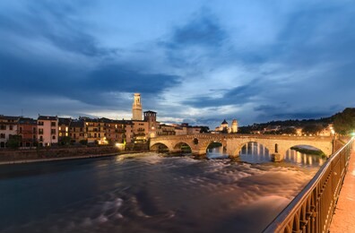 panoramic view to bridge ponte pietra in verona on adige river in the evening